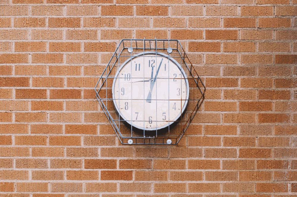 clock on a brick wall by Aubrey Rose Odom
