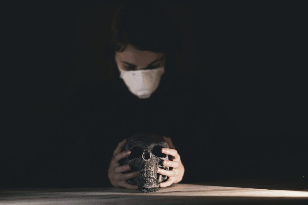masked woman holding a skull by Engin Akyurt