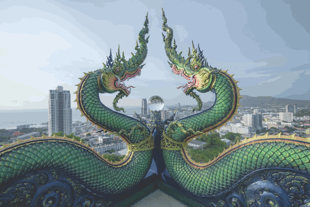 dragons in a cityscape by Autthaporn Pradidpong